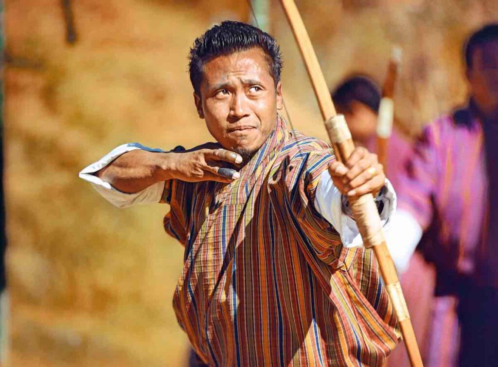 Bhutanese archer throwing an arrow as part of the traditional sport competition.