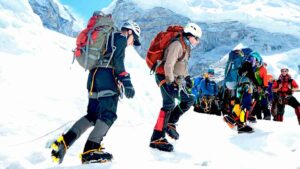 group of high-altitude mountain climbers walking on glacier and heading down to basecamp