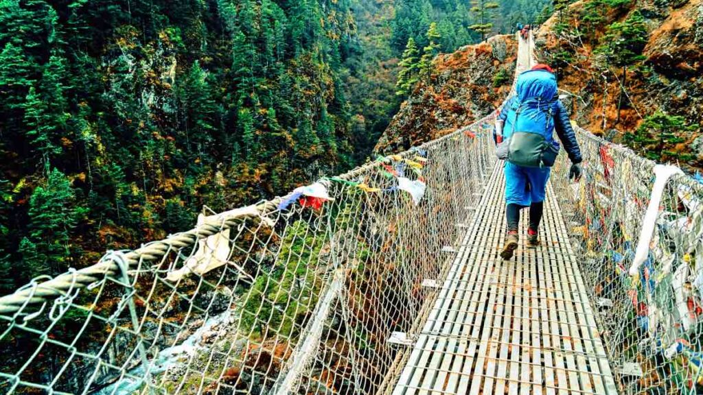 Suspension bridge crossing over the lusgh Everest valley in Nepal on teh route to Namche Bazar.