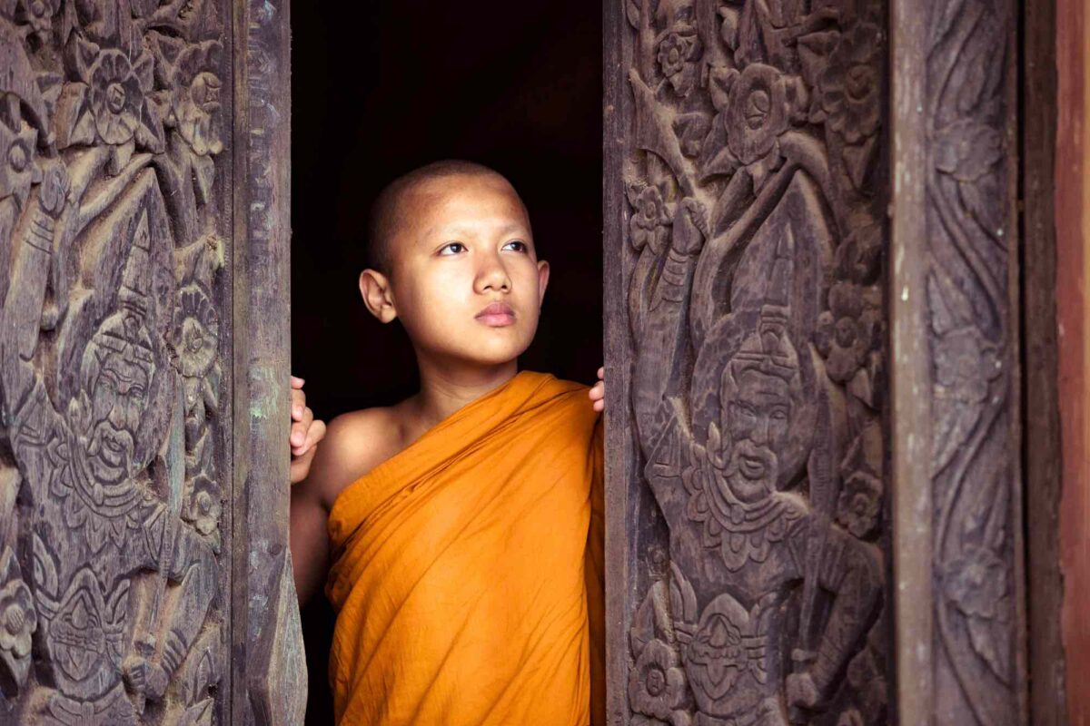 youg monk at the entrance of a temple door in thallnd