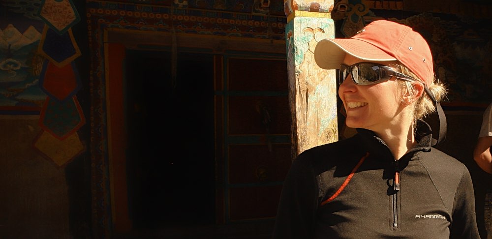 woman on a trek to remore dolpo walking along a Buddhist monastery