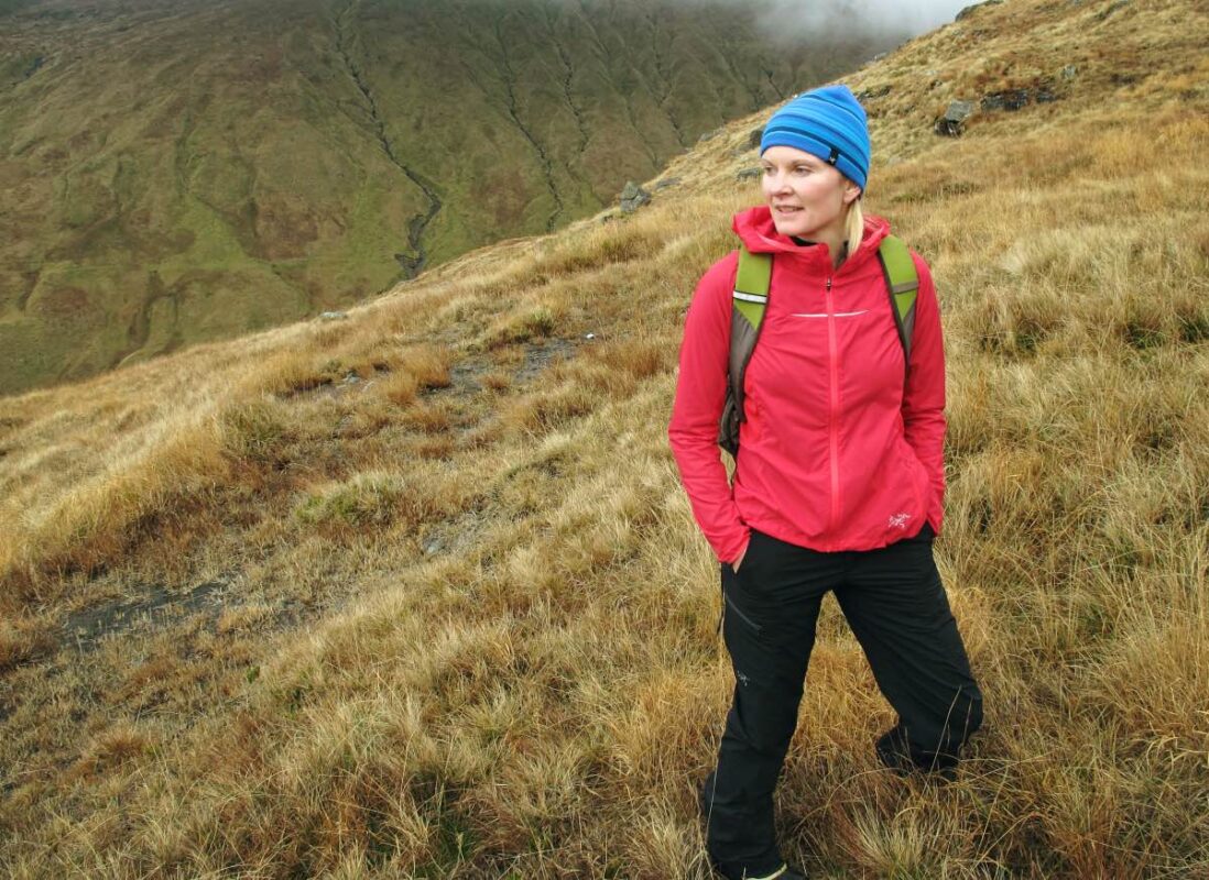 Woman looking on the horizon on a mountain route in scotland