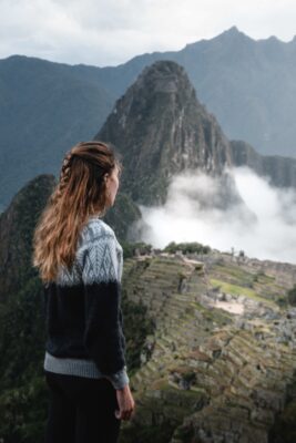 Female traveller admiring the ancient Inca citadel of Machu Picchu in Peru at sunrise